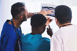 Three doctors discussing the x-ray