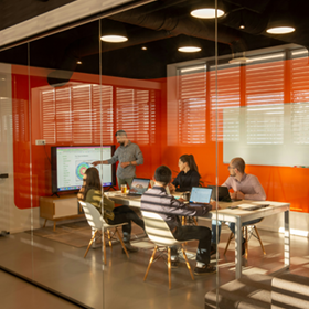 Compañeros de trabajo reunidos en una sala de conferencias para revisar una gráfica.